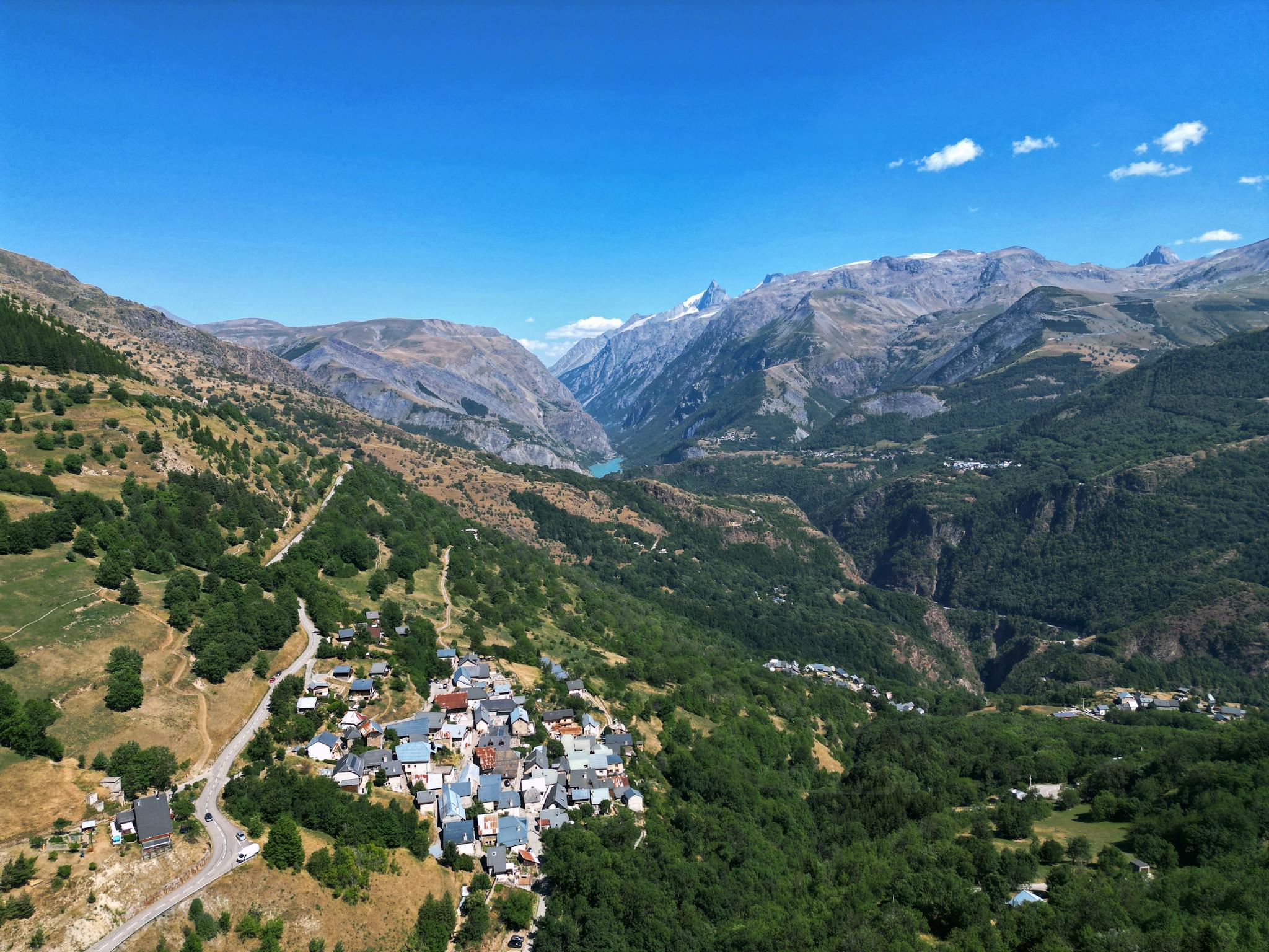 Stunning aerial landscape of Auris, France with mountains, valleys, and clear blue skies.